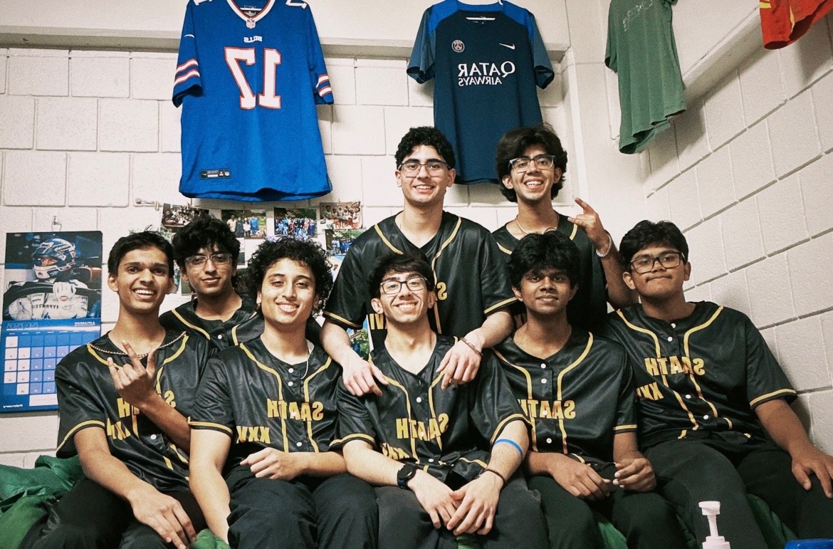 The SAATH dance team posing together in matching black and gold jerseys